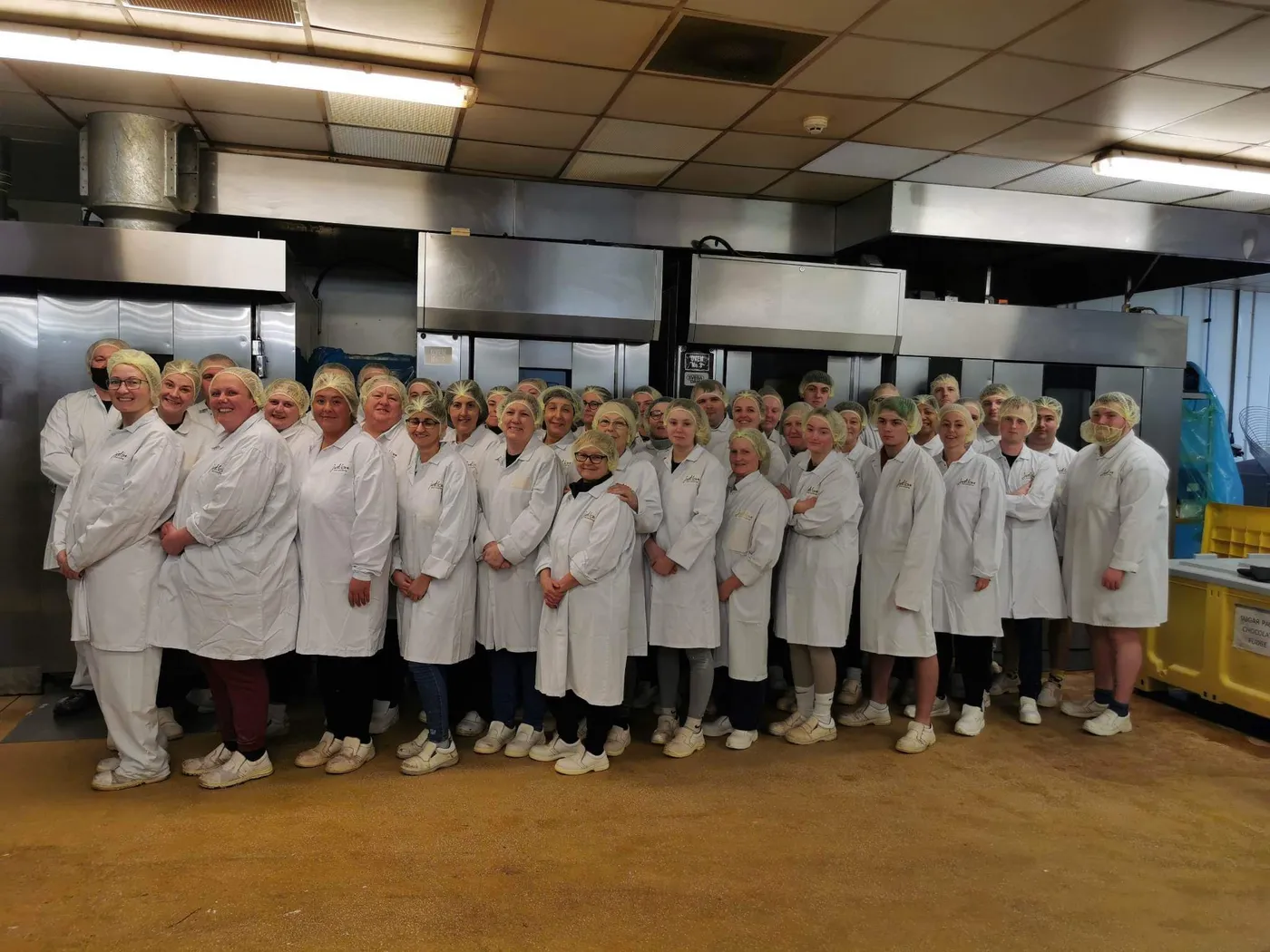 The bakery team in their whites in front of the ovens